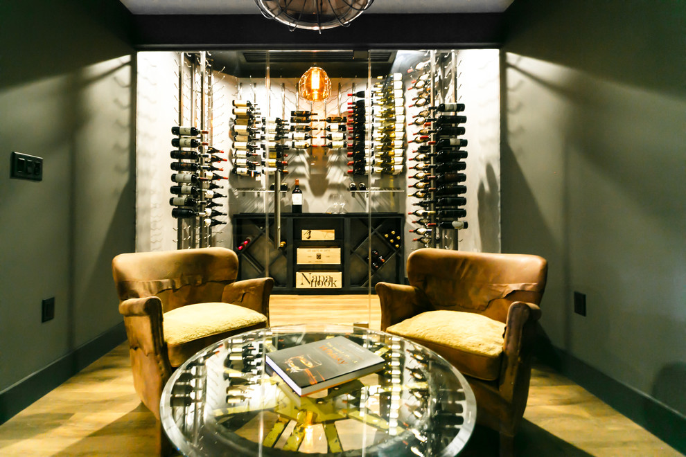 Photo of a medium sized contemporary wine cellar in New York with dark hardwood flooring and display racks.