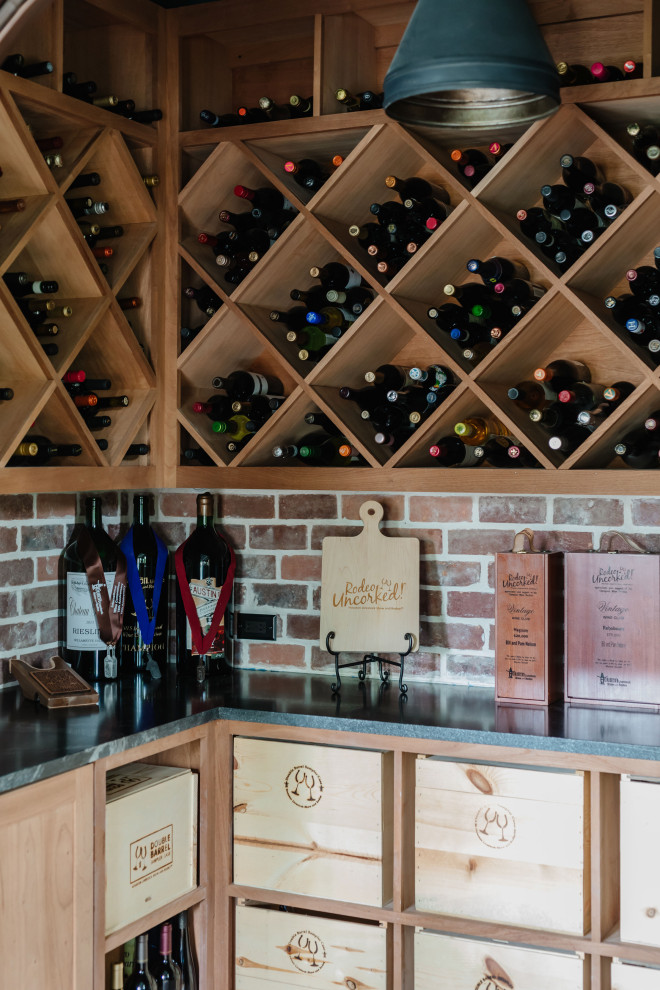Medium sized rural wine cellar in Houston with brick flooring, cube storage and red floors.