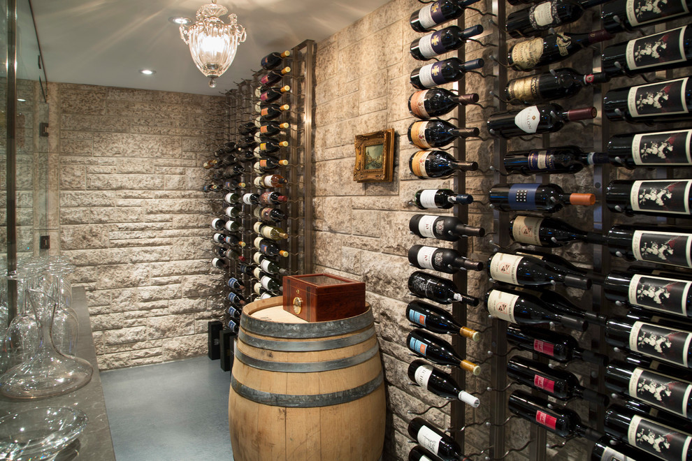 Cette photo montre une grande cave à vin chic avec sol en béton ciré et des casiers.