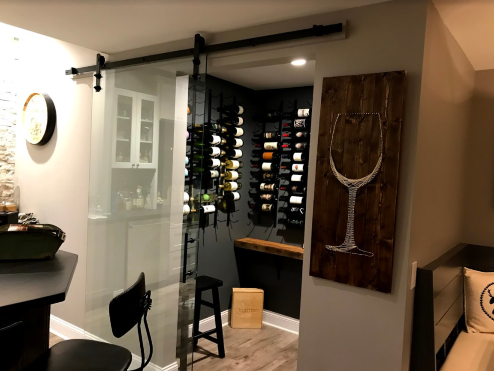 Design ideas for a small traditional wine cellar in Other with light hardwood flooring, storage racks and beige floors.
