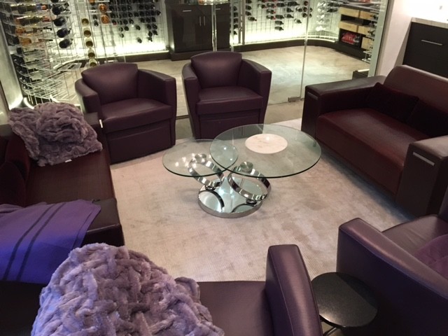 This is an example of a large modern wine cellar in Dallas with carpet and display racks.