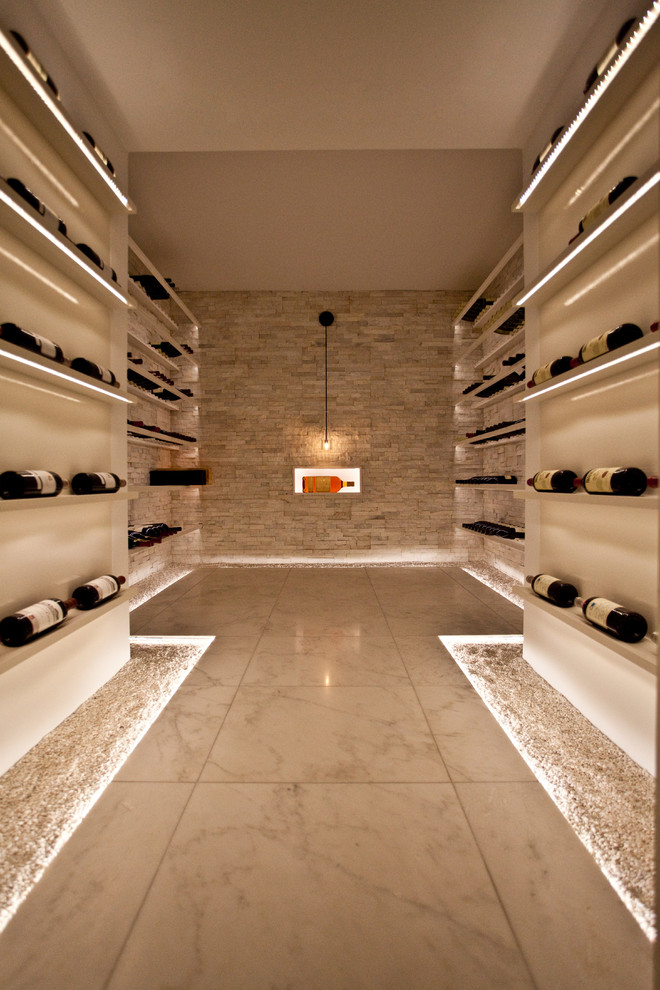 Inspiration for a large contemporary marble floor wine cellar remodel in Toronto with display racks