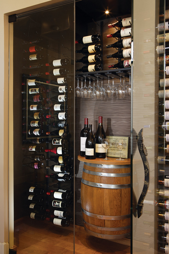 Example of a mid-sized transitional medium tone wood floor wine cellar design in Phoenix with display racks