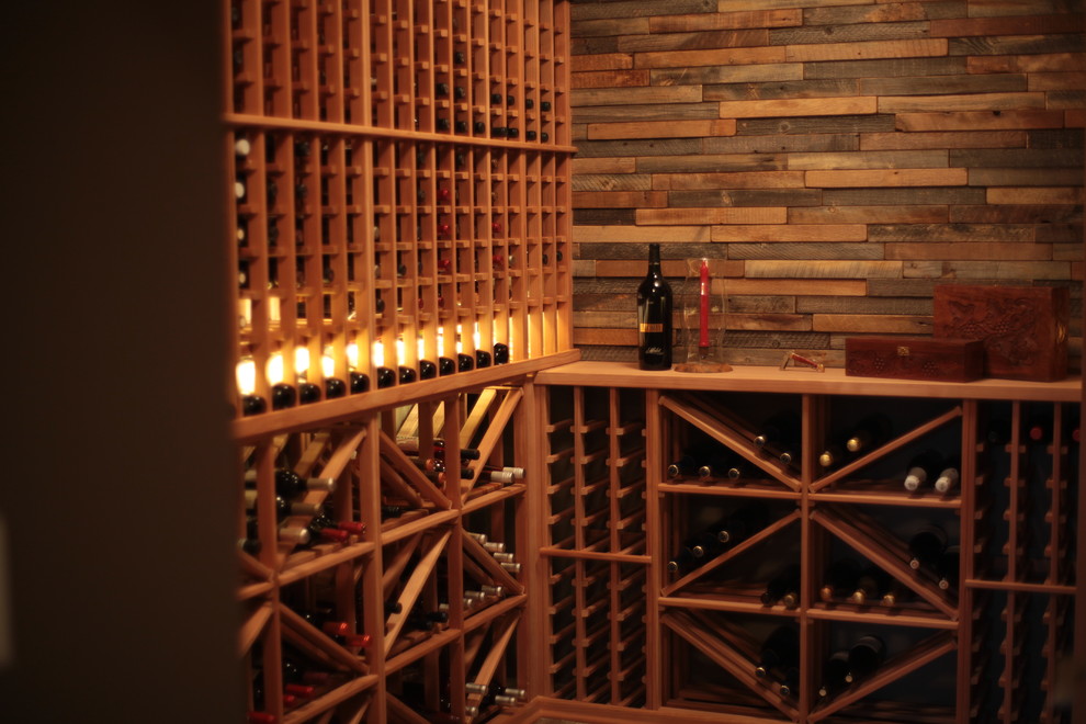 Idée de décoration pour une cave à vin tradition de taille moyenne avec des casiers et un sol en bois brun.