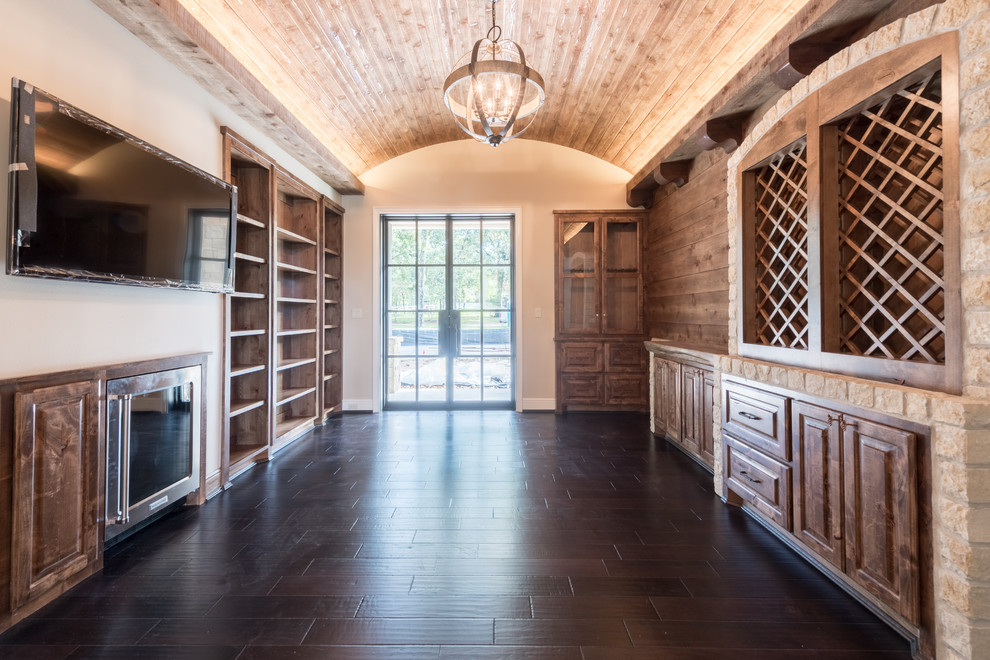 This is an example of an expansive classic wine cellar in Houston with dark hardwood flooring, storage racks and brown floors.
