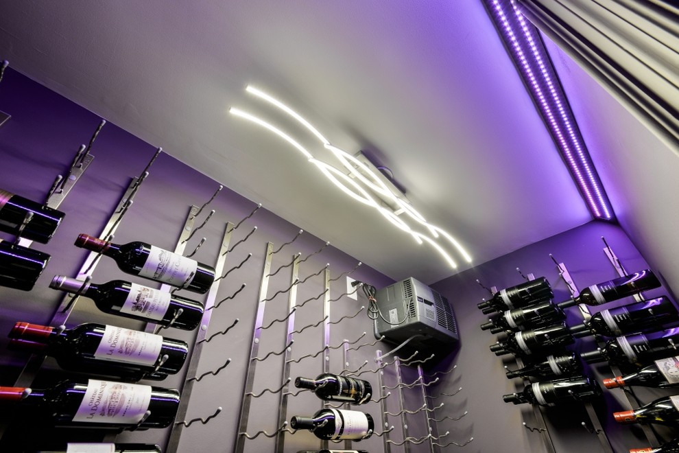 This is an example of a medium sized modern wine cellar in Toronto with porcelain flooring, display racks and black floors.