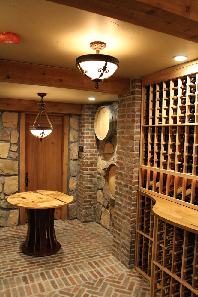 Wine cellar - large rustic brick floor wine cellar idea in Boston with storage racks