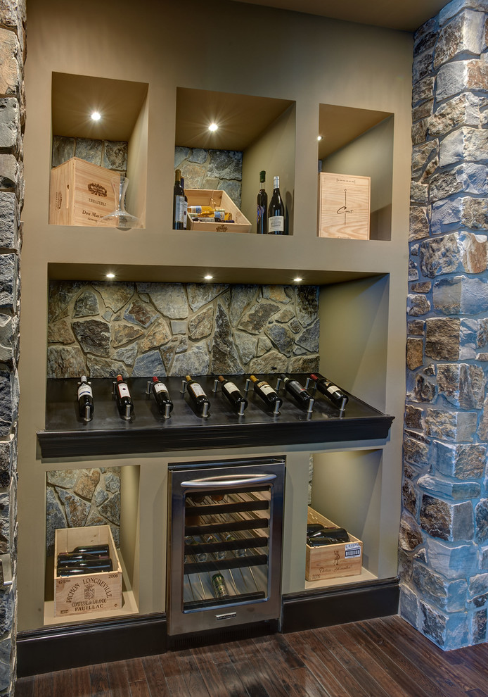 Idée de décoration pour une cave à vin tradition avec un sol en bois brun et un présentoir.