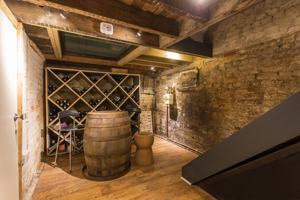 Bild på en mellanstor vintage vinkällare, med ljust trägolv, vinställ med diagonal vinförvaring och brunt golv