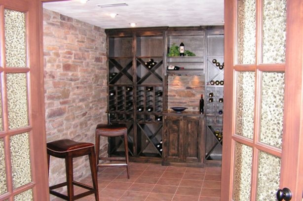 Exempel på en mellanstor rustik vinkällare, med klinkergolv i terrakotta, vinhyllor och rött golv