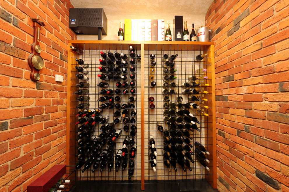 Réalisation d'une cave à vin design de taille moyenne avec un sol en ardoise et des casiers.