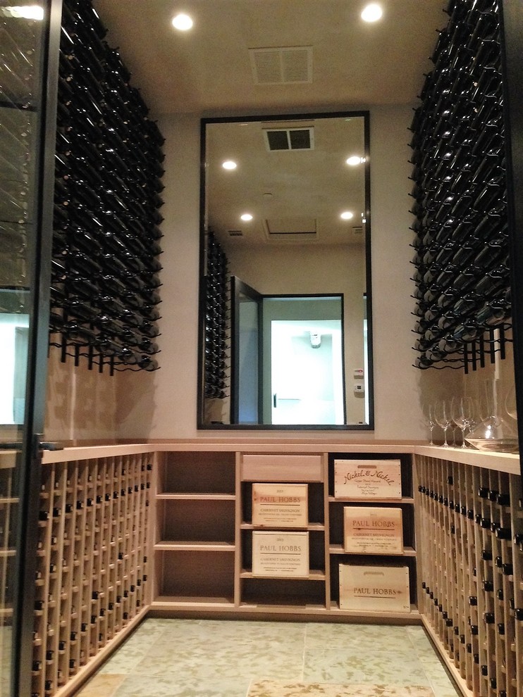 Idée de décoration pour une grande cave à vin minimaliste avec un sol en travertin et des casiers.