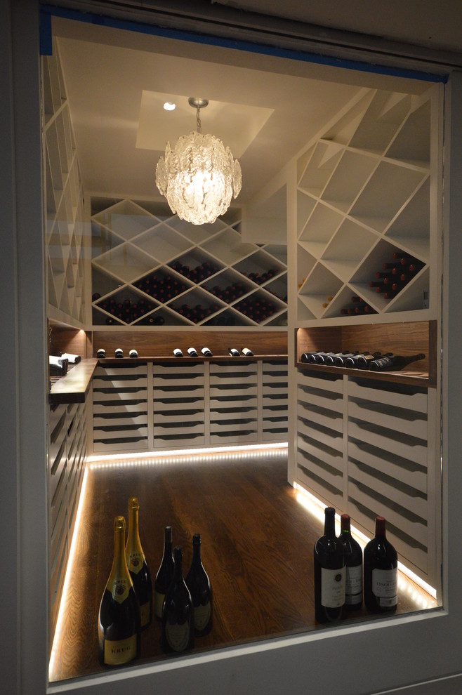 Wine cellar - mid-sized contemporary medium tone wood floor wine cellar idea in New York with diamond bins