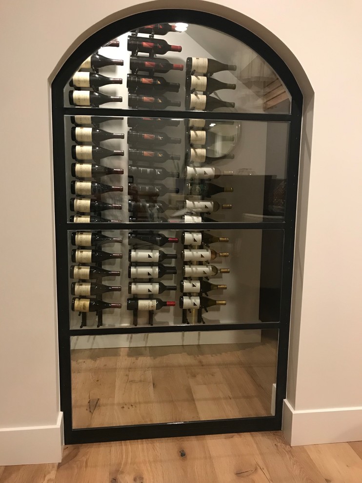 Inspiration for a small contemporary medium tone wood floor wine cellar remodel in Orange County with storage racks