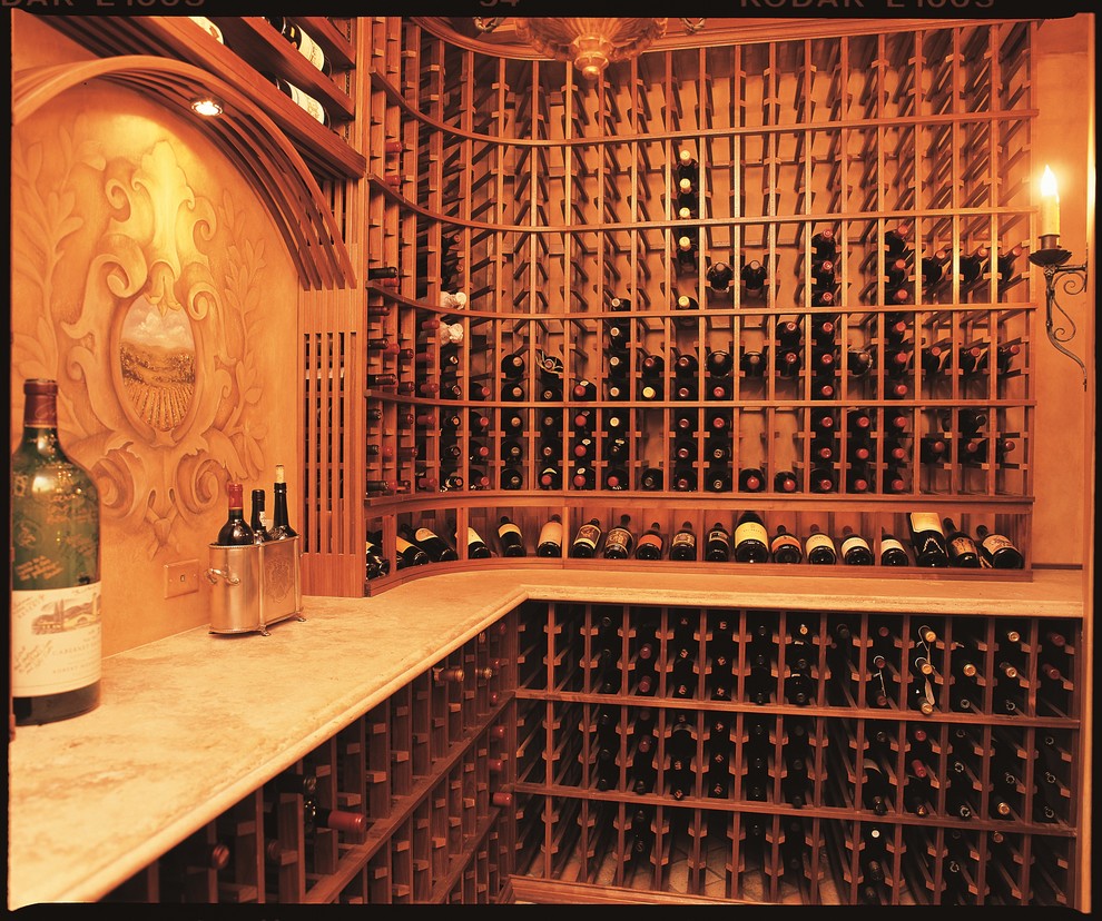 Aménagement d'une grande cave à vin classique avec tomettes au sol et un présentoir.