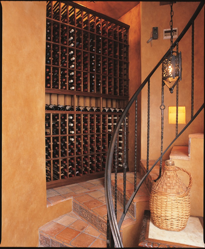 Inspiration for a large timeless terra-cotta tile wine cellar remodel in Orange County with display racks