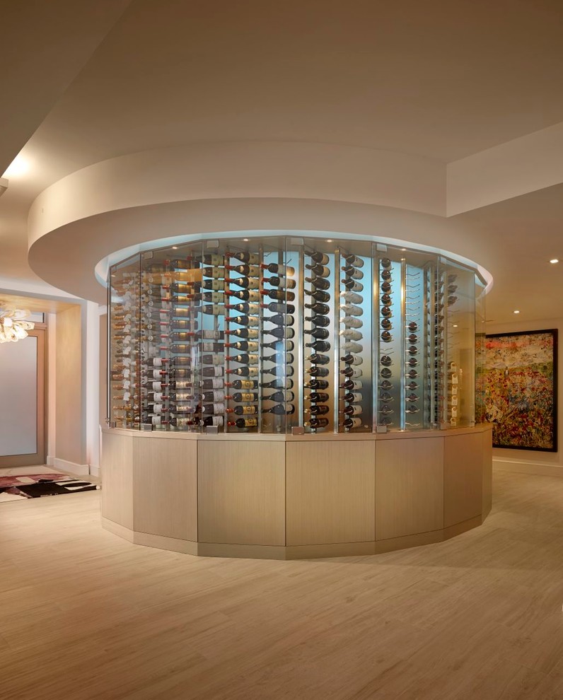 Réalisation d'une cave à vin design de taille moyenne avec parquet clair.