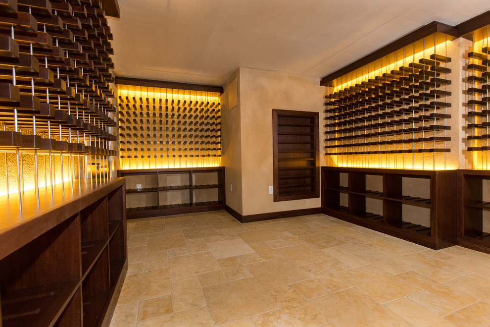 Exemple d'une très grande cave à vin tendance avec un sol en calcaire, des casiers et un sol beige.