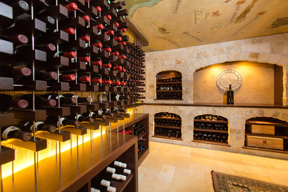 Bild på en mycket stor medelhavsstil vinkällare, med kalkstensgolv, vinhyllor och beiget golv