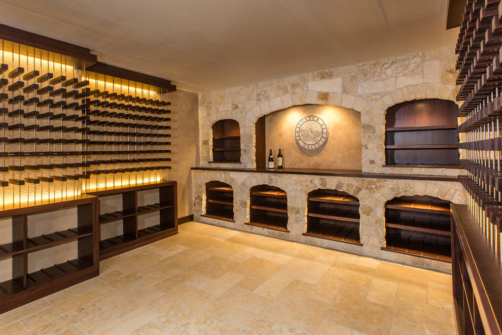 Cette photo montre une très grande cave à vin méditerranéenne avec un sol en calcaire, des casiers et un sol beige.