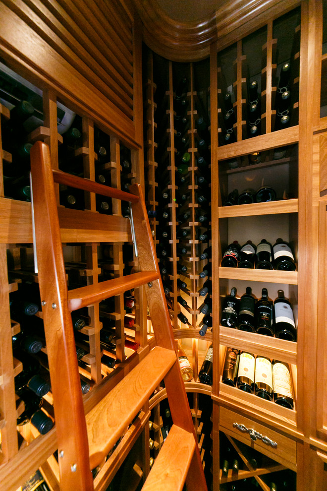 Cette photo montre une petite cave à vin chic avec parquet foncé et un présentoir.