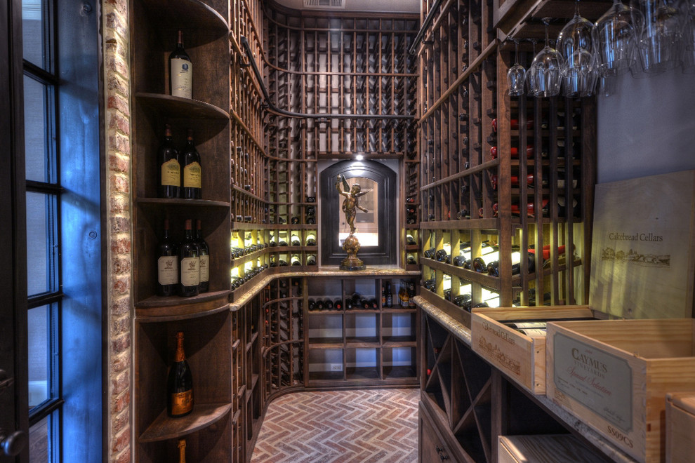 Classic wine cellar in Houston with brick flooring, storage racks and red floors.