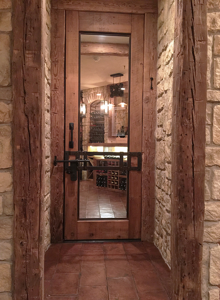 Cette photo montre une cave à vin montagne de taille moyenne avec tomettes au sol, des casiers et un sol marron.