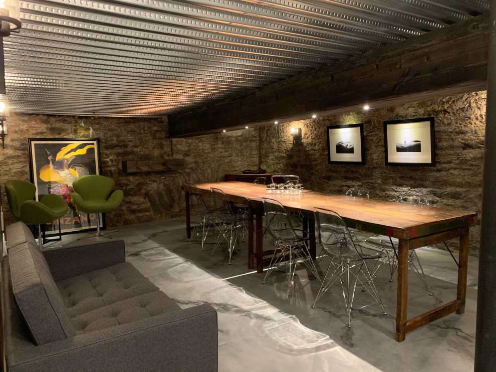 This is an example of a small bohemian wine cellar in Cincinnati with concrete flooring, display racks and grey floors.
