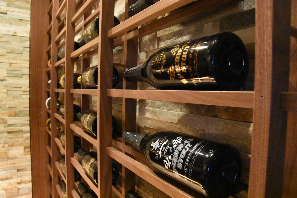 Cette image montre une cave à vin traditionnelle de taille moyenne avec tomettes au sol et un présentoir.