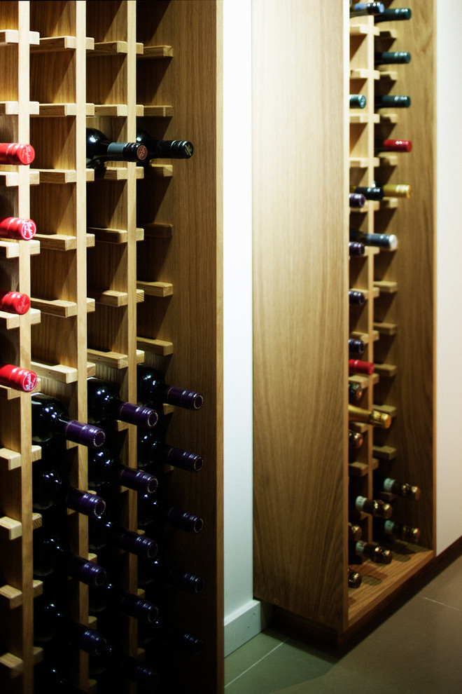 This is an example of a medium sized contemporary wine cellar in Sydney with porcelain flooring and storage racks.