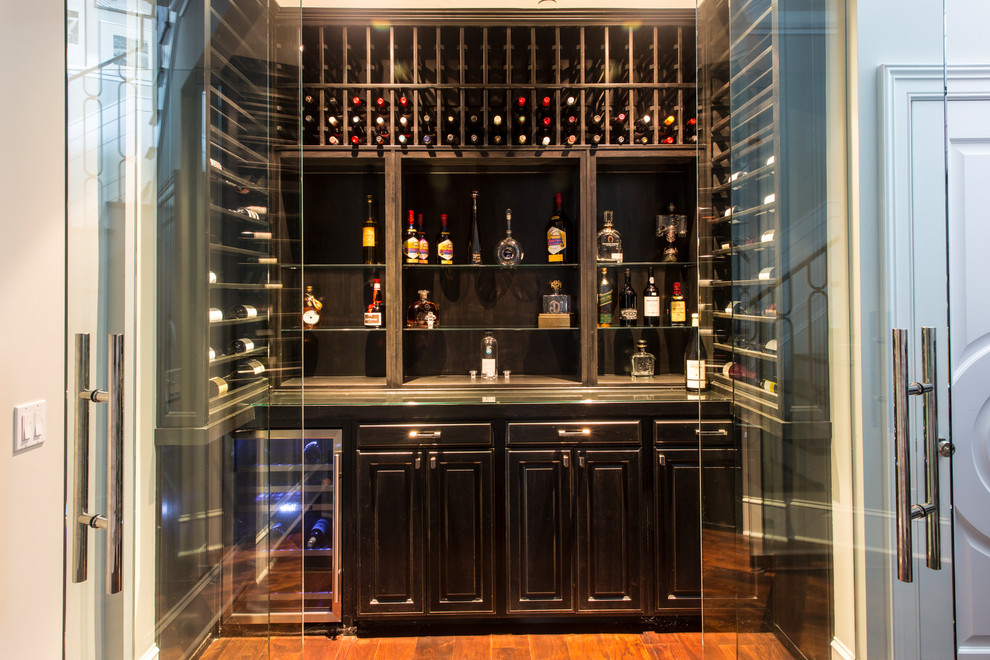 Example of a mid-sized transitional medium tone wood floor and brown floor wine cellar design in Los Angeles with storage racks