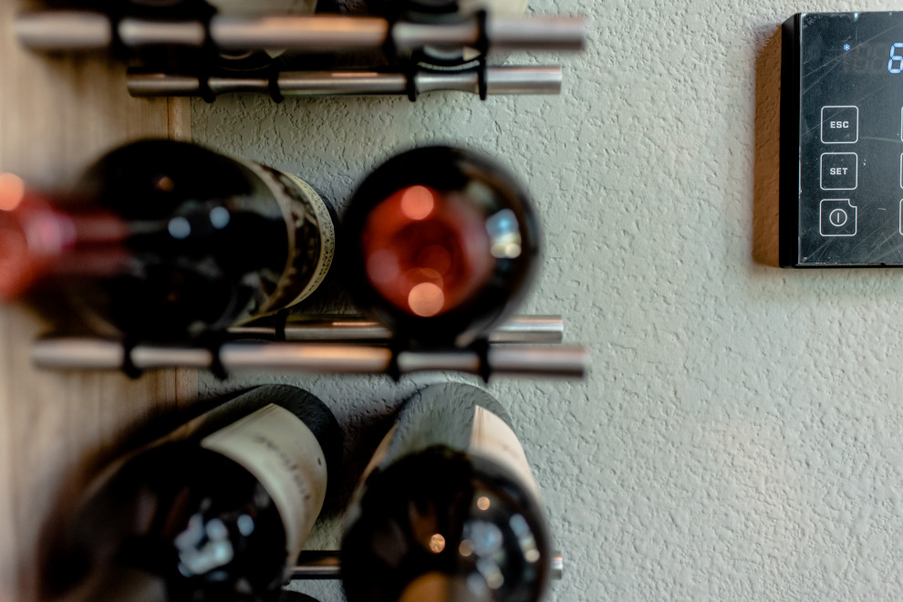 Cette photo montre une cave à vin tendance de taille moyenne avec des casiers et un sol marron.