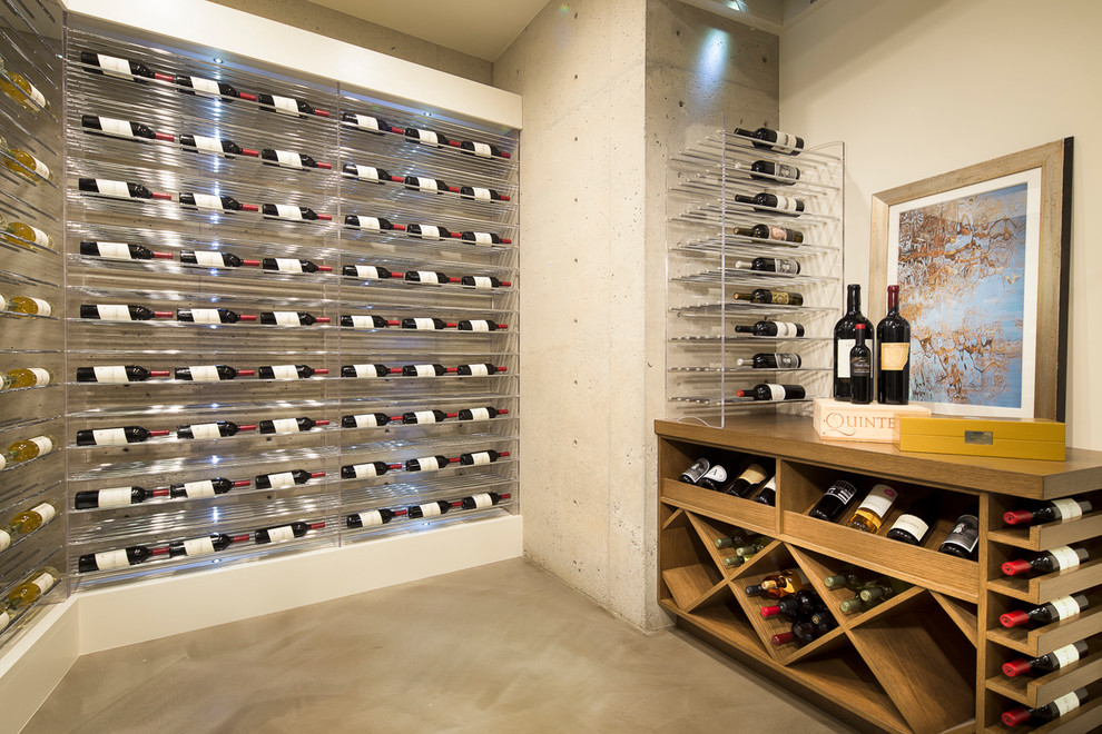 Cette image montre une cave à vin design avec un présentoir et sol en béton ciré.