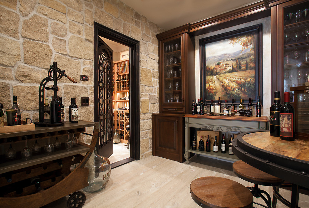 This is an example of a traditional wine cellar in Orange County with light hardwood flooring and display racks.