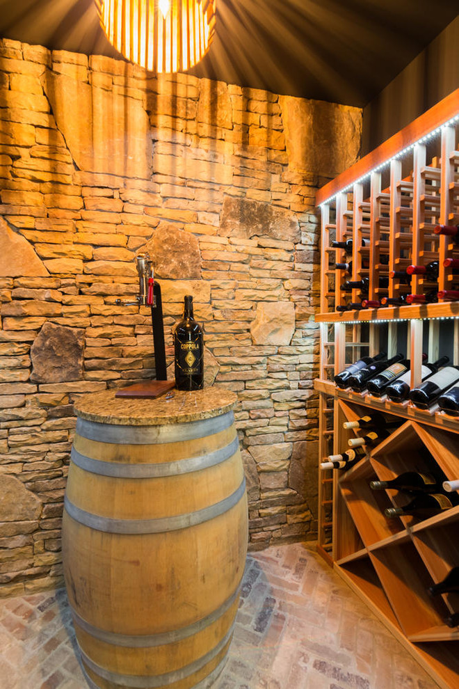 Réalisation d'une cave à vin chalet de taille moyenne avec des casiers losange, un sol en brique et un sol marron.