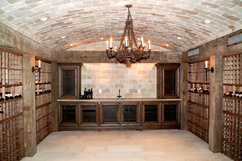 Bild på en stor medelhavsstil vinkällare, med travertin golv, vinhyllor och beiget golv