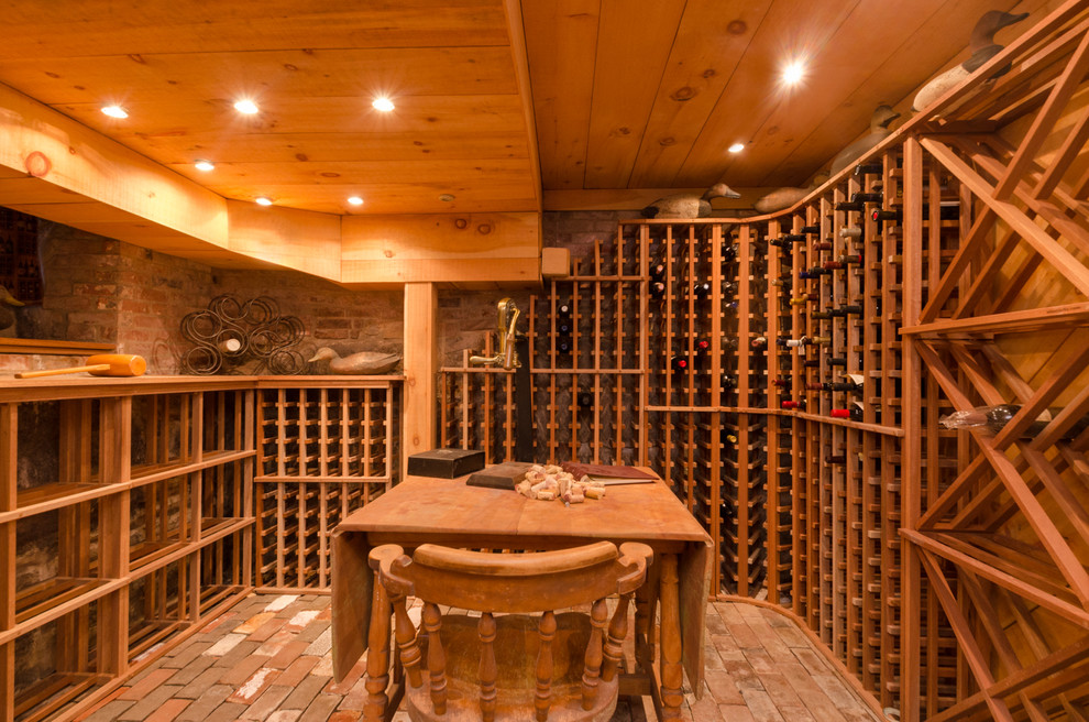 Huge elegant brick floor wine cellar photo in Boston with storage racks