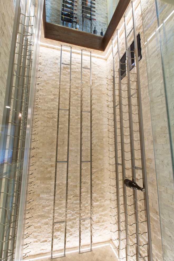 Bild på en mellanstor funkis vinkällare, med travertin golv, vindisplay och beiget golv