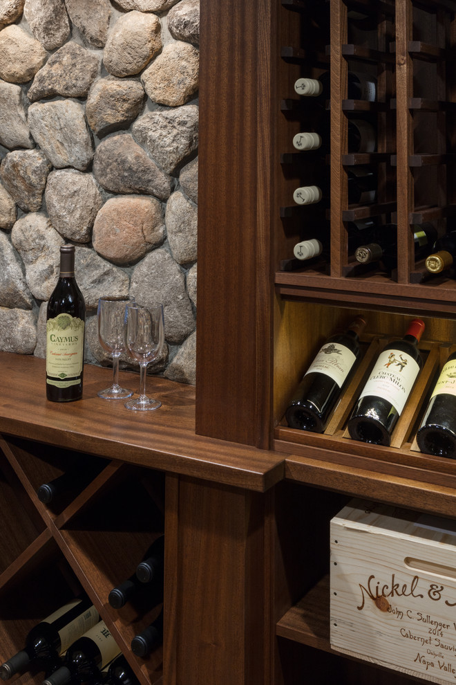 This is an example of a traditional wine cellar in Boston with ceramic flooring, storage racks and brown floors.