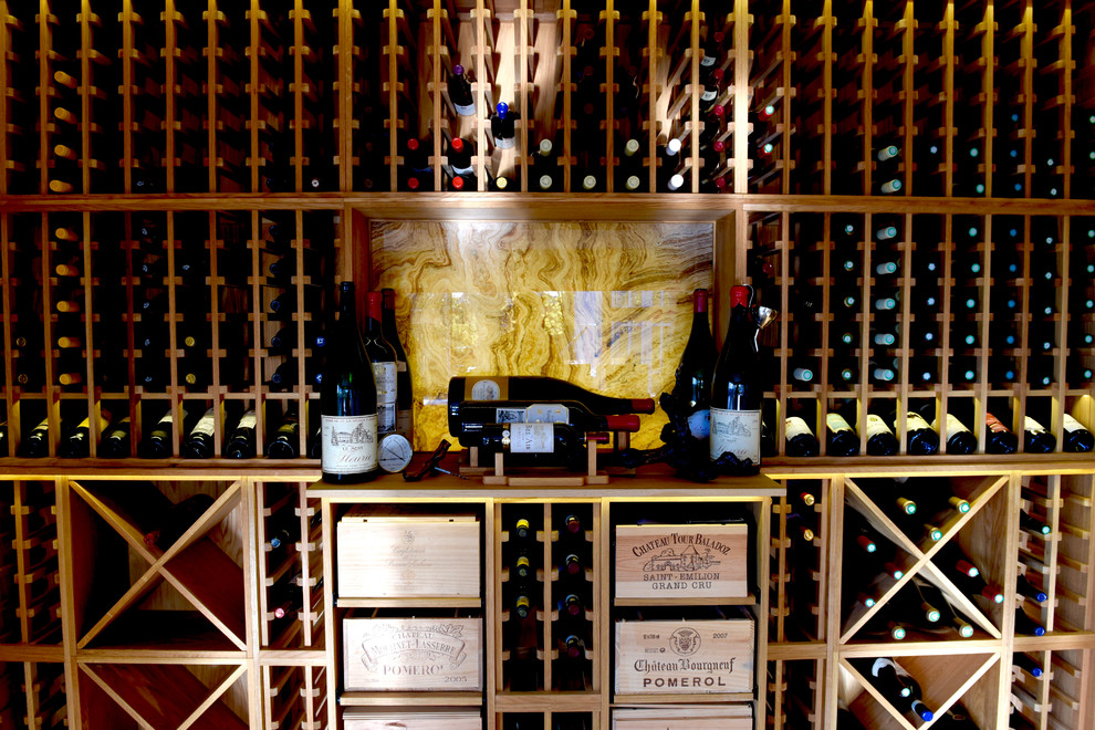 Cette image montre une grande cave à vin design avec des casiers, parquet clair et un sol marron.