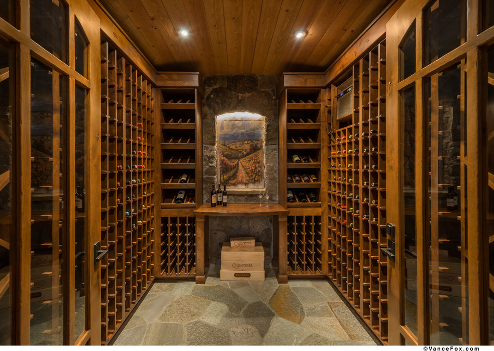 Aménagement d'une grande cave à vin craftsman avec un sol en ardoise et des casiers.