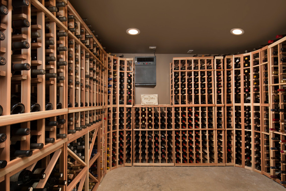 Foto på en mellanstor amerikansk vinkällare, med betonggolv, vinhyllor och grått golv