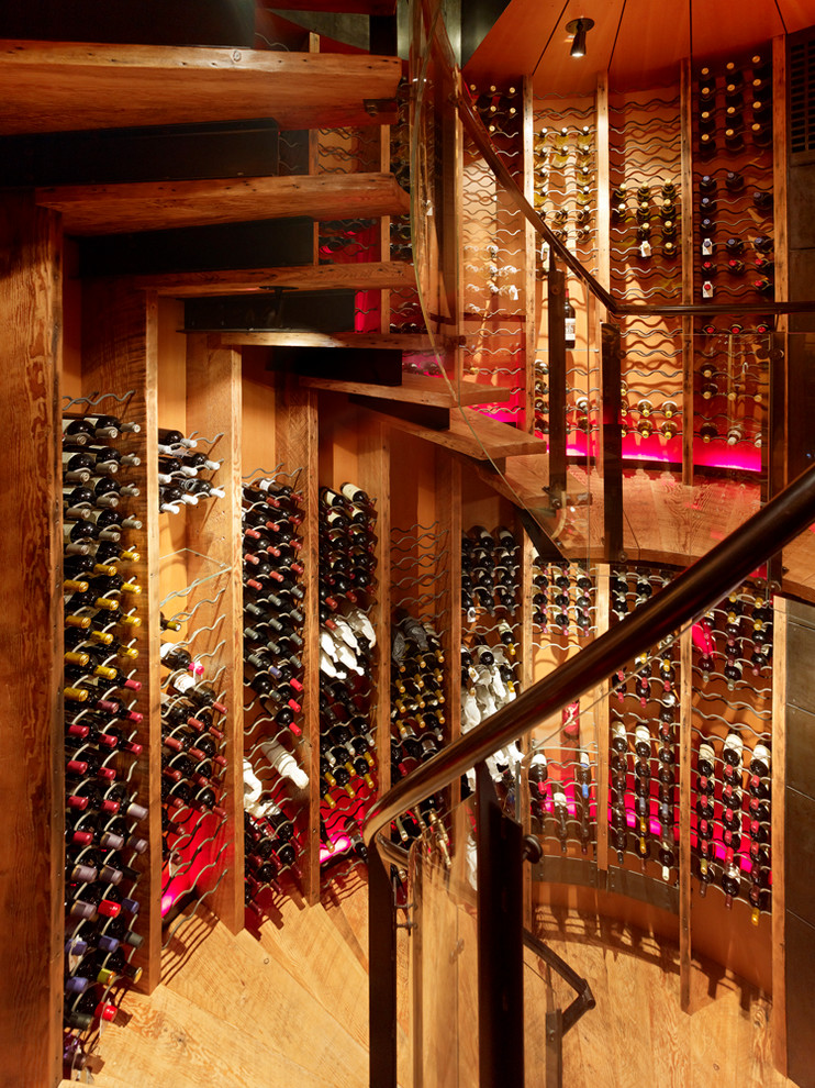 Example of a mountain style medium tone wood floor and yellow floor wine cellar design in Salt Lake City with storage racks
