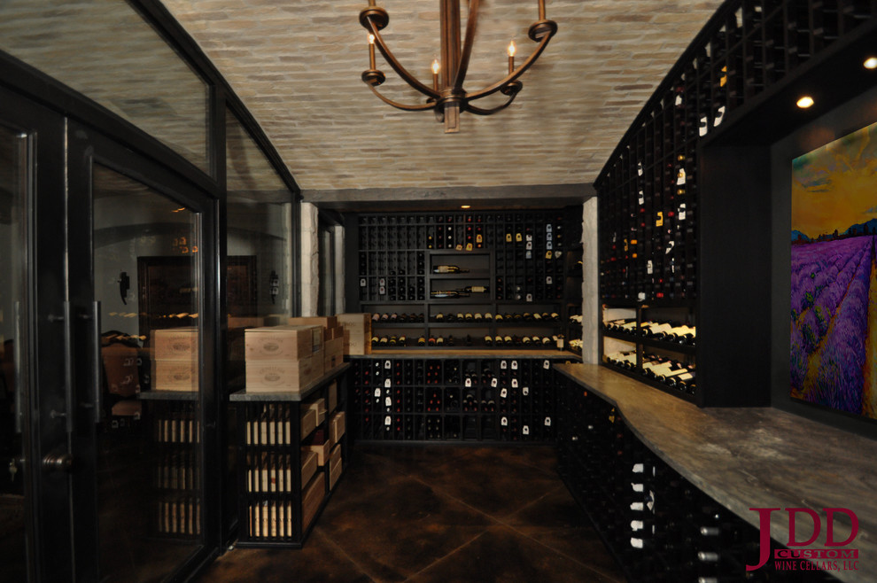 Inspiration for a large mediterranean wine cellar in San Diego with concrete flooring and display racks.