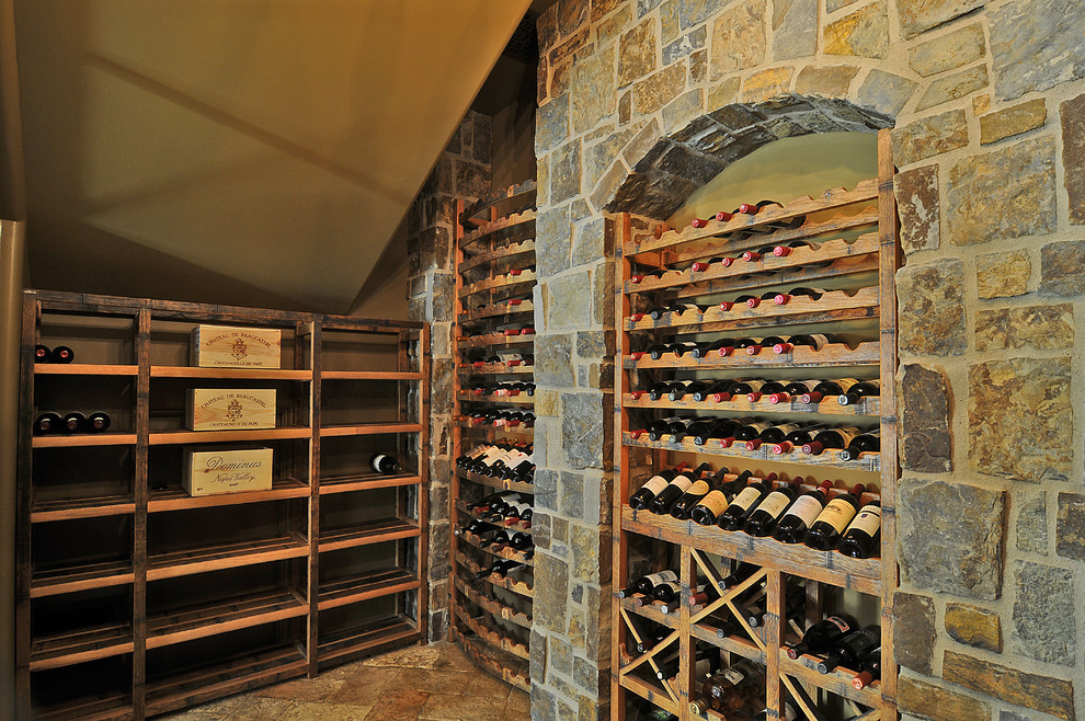 Large classic wine cellar in Phoenix with limestone flooring, storage racks and beige floors.