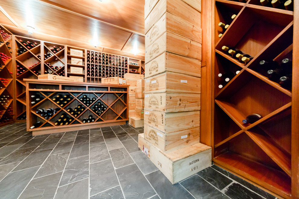 Example of a large trendy slate floor and gray floor wine cellar design in New York with storage racks