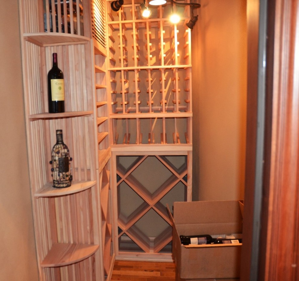 Aménagement d'une petite cave à vin classique avec un sol en bois brun et des casiers.