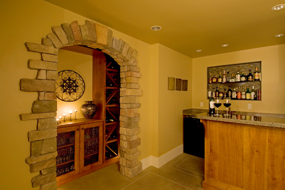 Aménagement d'une grande cave à vin contemporaine avec sol en béton ciré et des casiers losange.