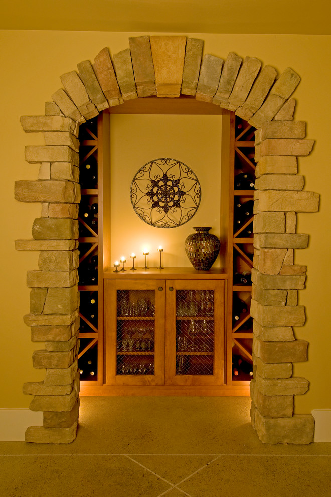 Cette image montre une grande cave à vin design avec sol en béton ciré et des casiers losange.