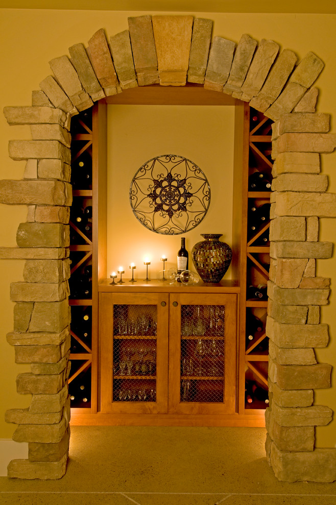Aménagement d'une cave à vin classique de taille moyenne avec un sol en travertin et des casiers losange.